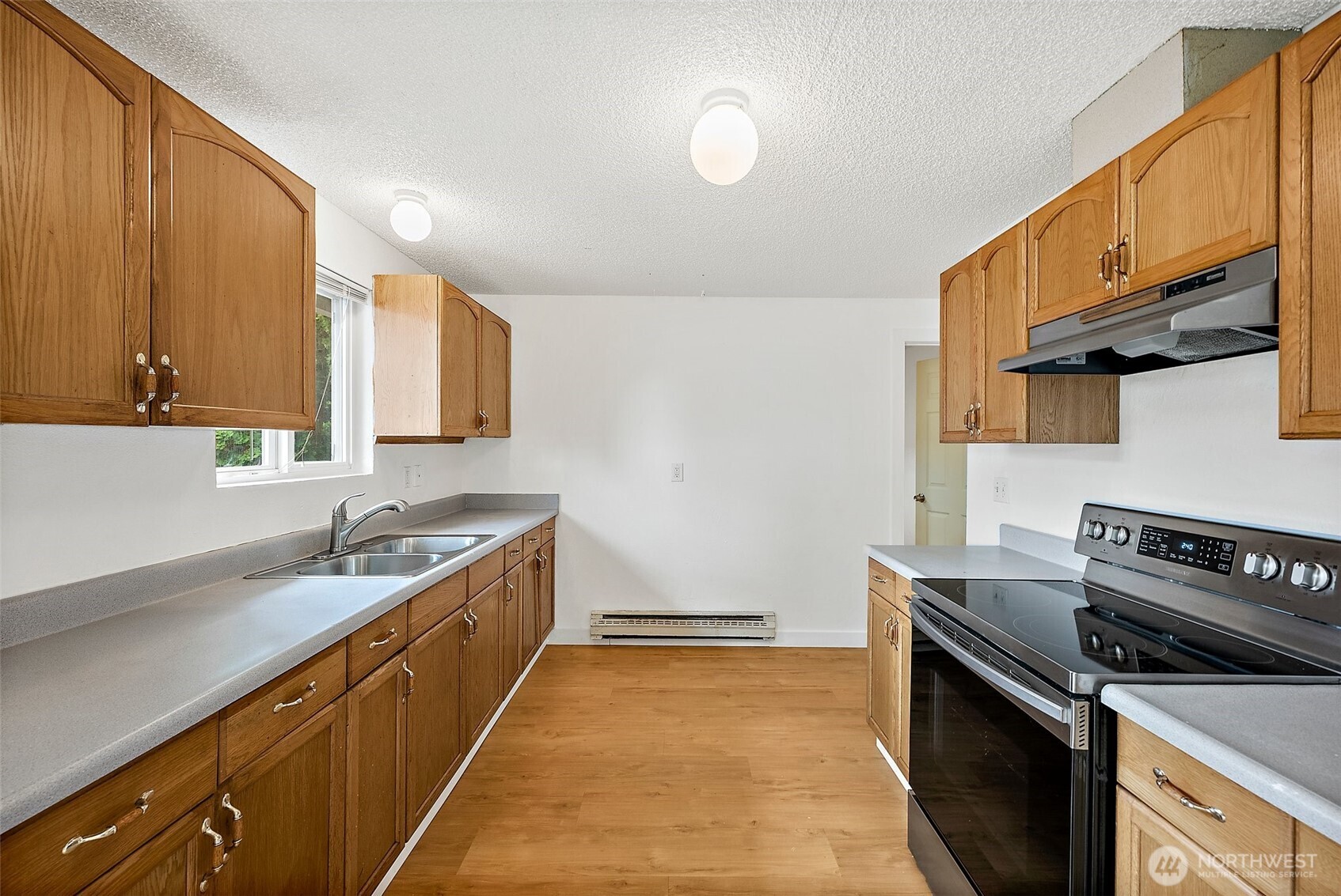 6610 South Madison Street Tacoma, WA 98409 - Photo 12 of 26 a kitchen with a sink stove and cabinets
