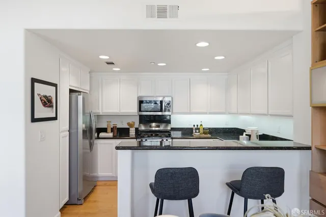 a kitchen with granite countertop a sink and a refrigerator