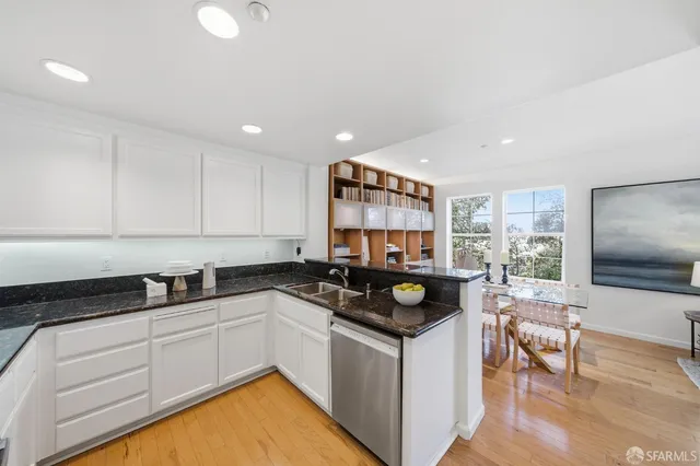 a kitchen with granite countertop a refrigerator a sink a stove and cabinets