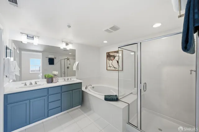 a spacious bathroom with a shower sink and mirror