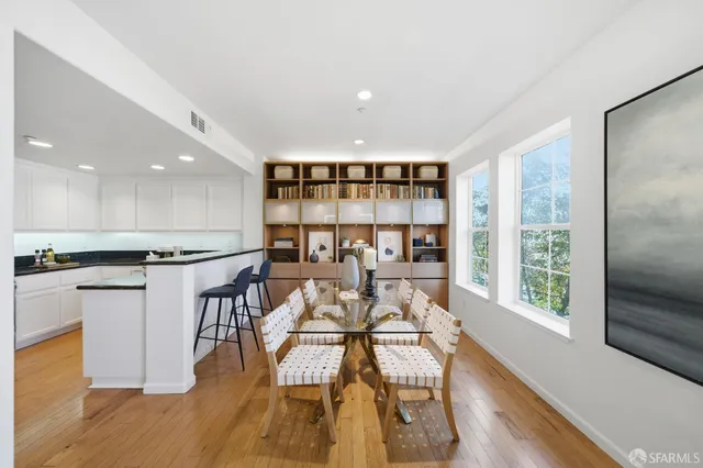 a living room with stainless steel appliances kitchen island a table and chairs in it