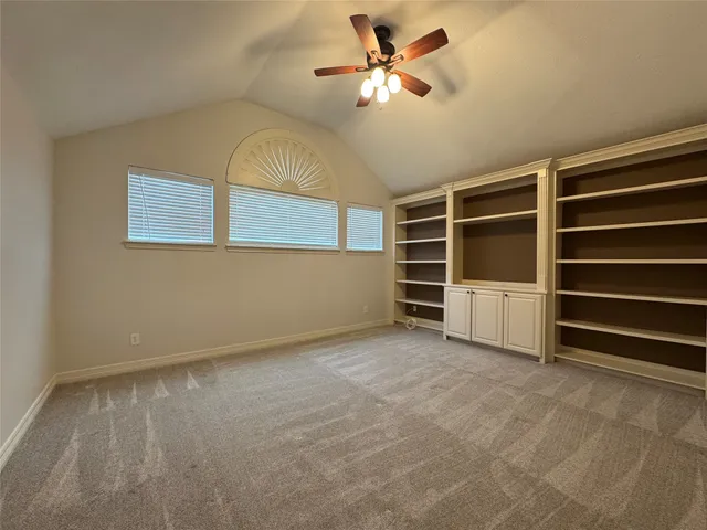 a view of an empty room with a ceiling fan