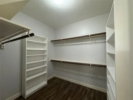 a view of walk in closet with empty racks