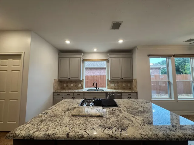 a large kitchen with a stove and a large window