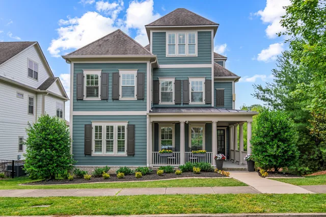 a living room with furniture kitchen view and a chandelier