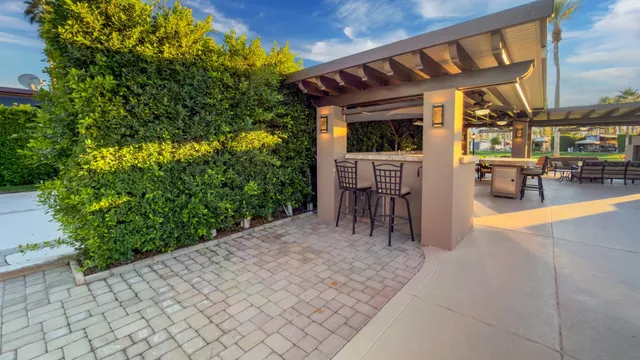 a view of a patio with table and chairs potted plants and large tree