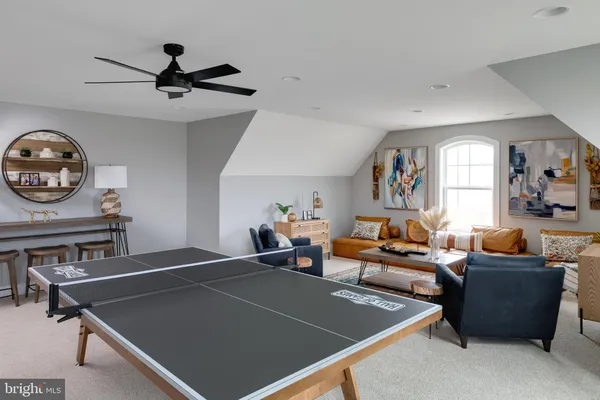 a living room with furniture a window and a fan
