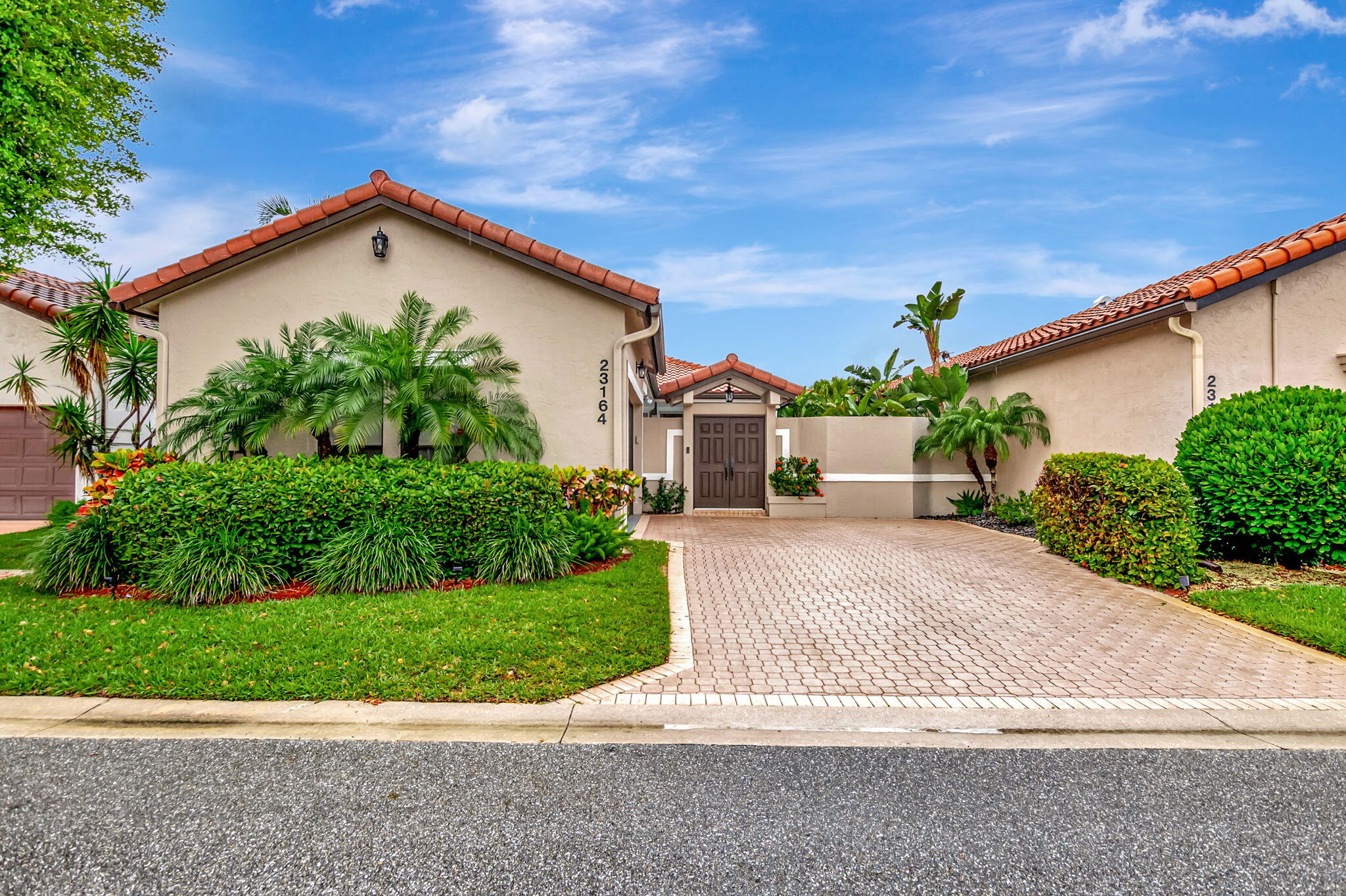 23164 Via Stel Boca Raton, FL 33433 - Photo 1 of 35 a front view of a house with a yard and potted plants