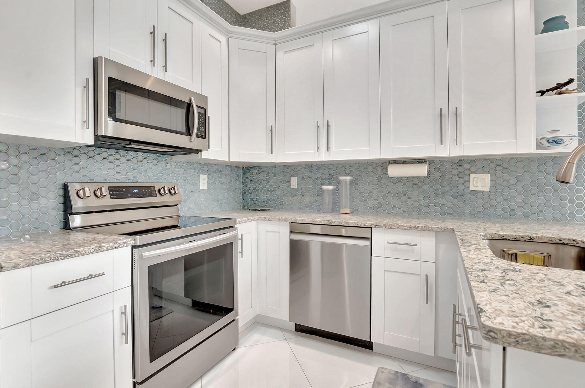 23164 Via Stel Boca Raton, FL 33433 - Photo 13 of 35 a kitchen with granite countertop white cabinets and white stainless steel appliances