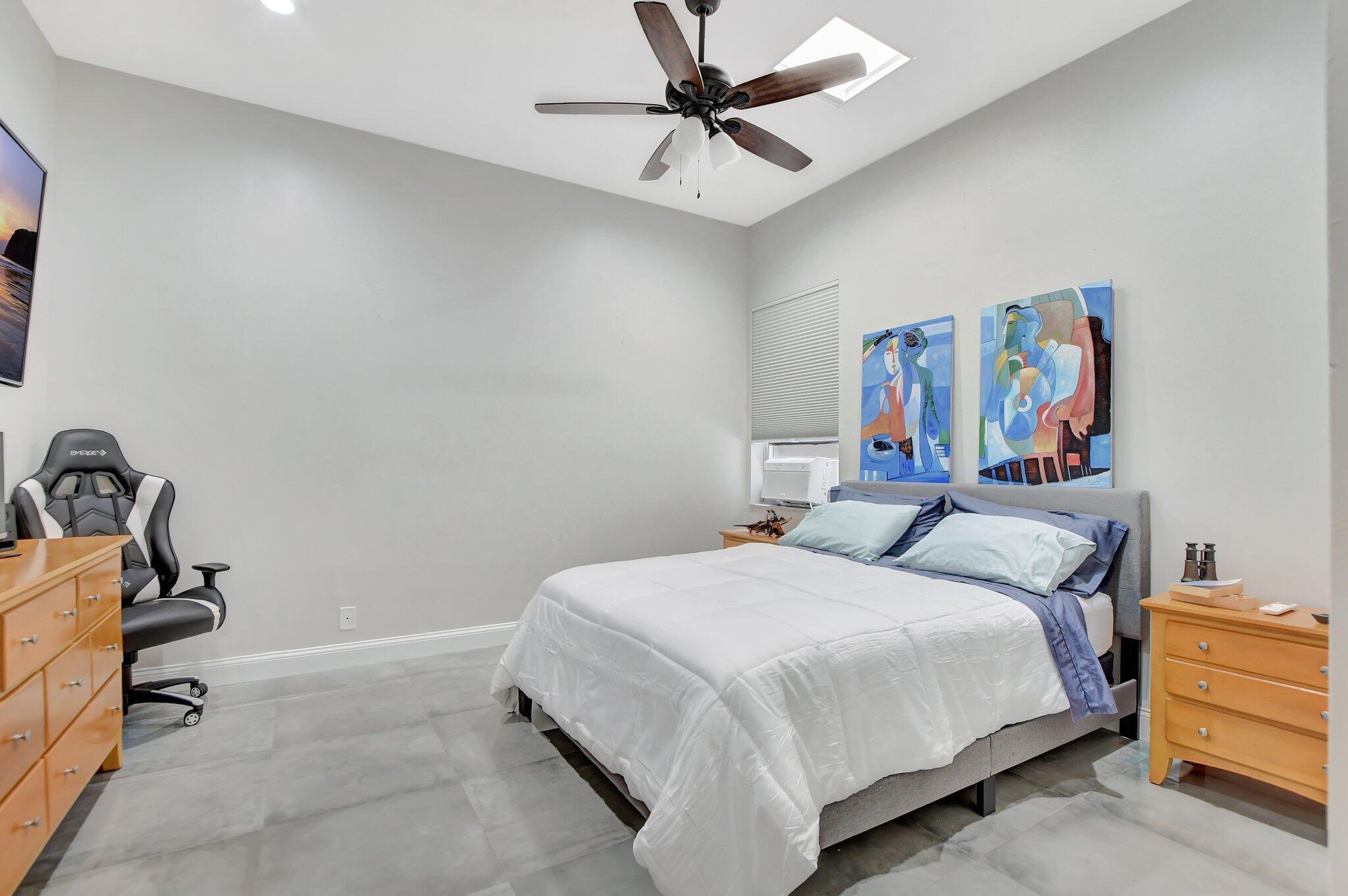 23164 Via Stel Boca Raton, FL 33433 - Photo 22 of 35 a bedroom with a bed and a chandelier