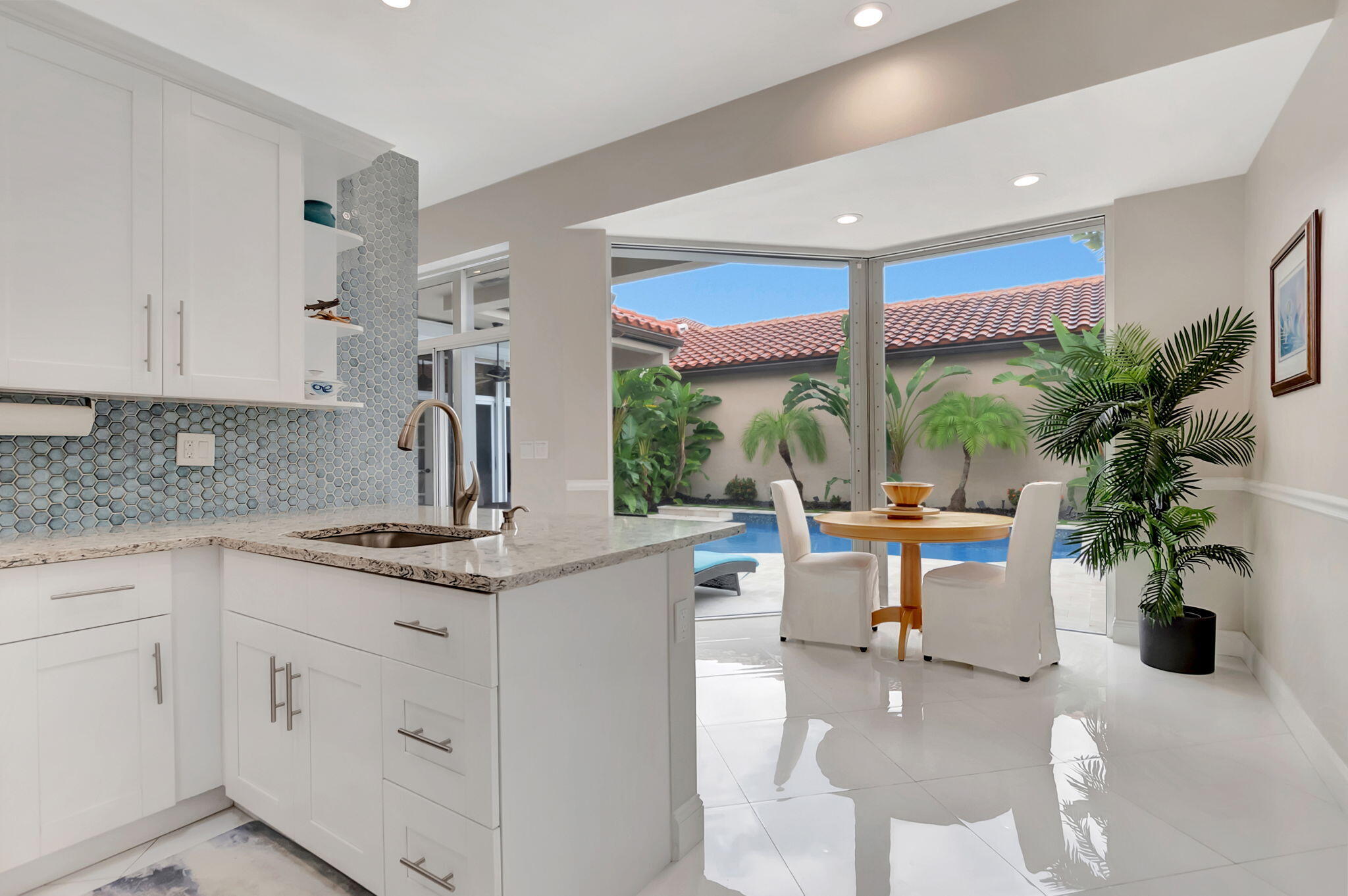 23164 Via Stel Boca Raton, FL 33433 - Photo 10 of 35 a kitchen with white cabinets and a potted plant