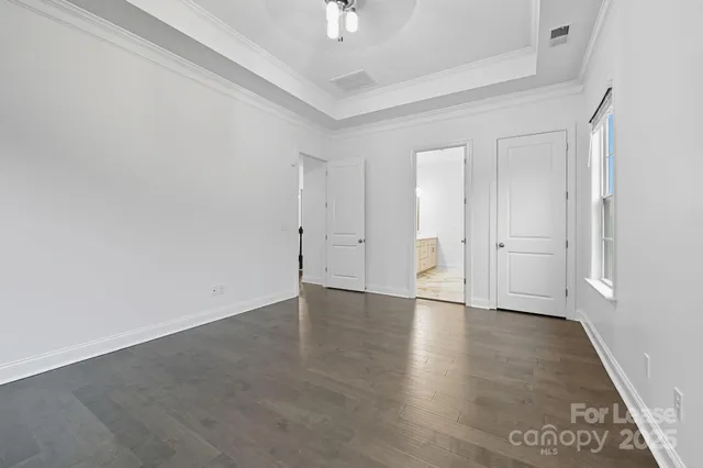 an empty room with wooden floor & windows