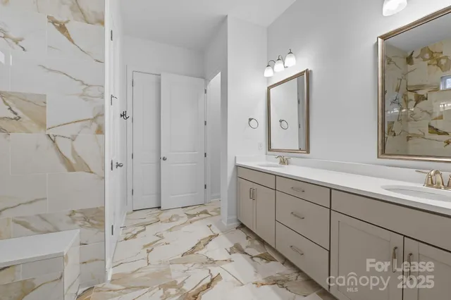 a spacious bathroom with a double vanity sink mirror and bathtub
