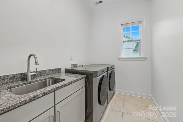 a utility room with sink dryer and washer
