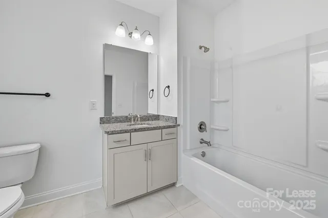 a bathroom with a granite countertop sink a toilet and shower
