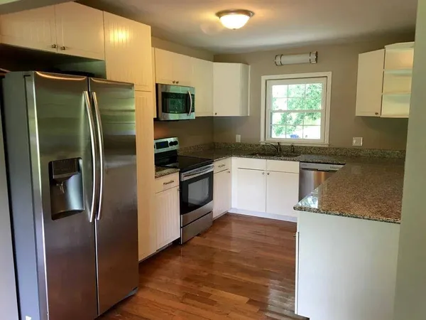 a kitchen with stainless steel appliances granite countertop a refrigerator a sink a stove a microwave and island