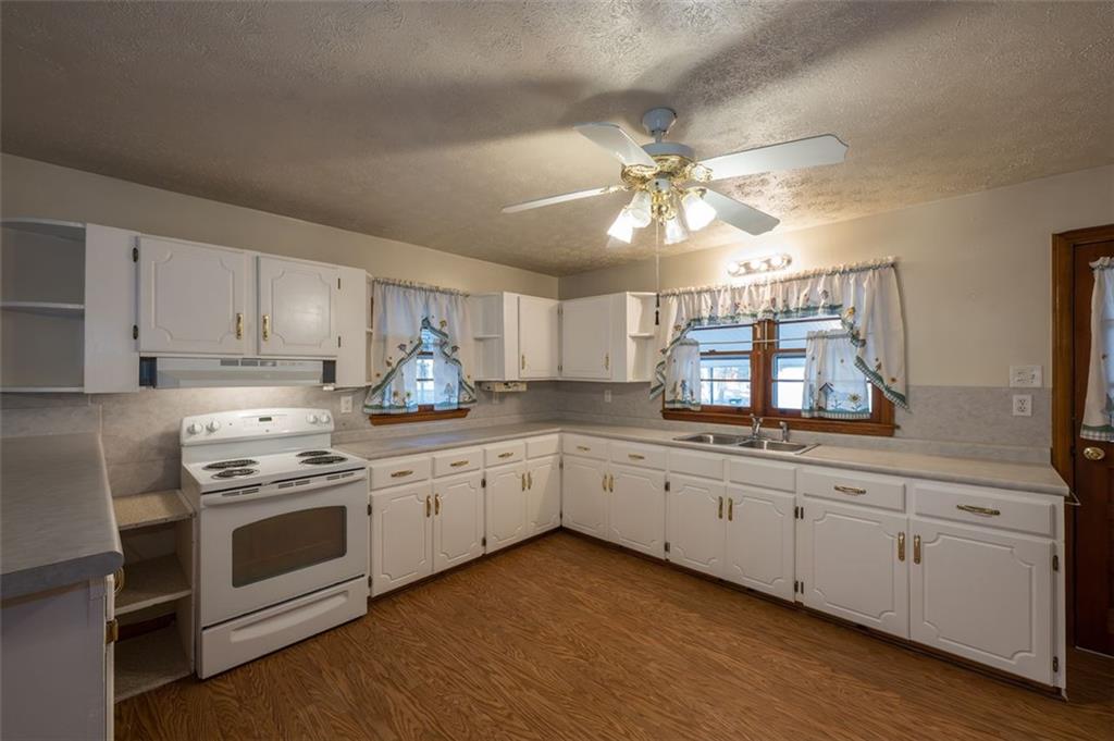 6822 Wallis Road Lithia Springs, GA 30122 - Photo 13 of 24 a kitchen with granite countertop white cabinets and white stainless steel appliances