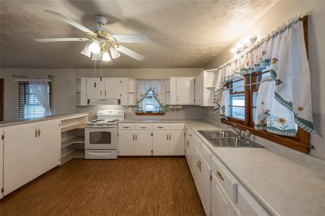 a kitchen with granite countertop white cabinets and white appliances