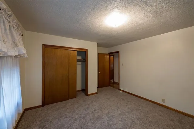 an empty room with closet and windows