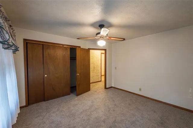 an empty room with fan and entrance