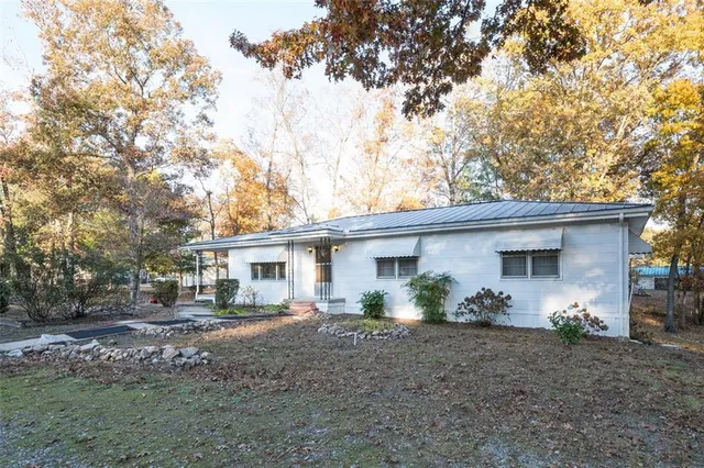 a view of a house with a yard and a tree