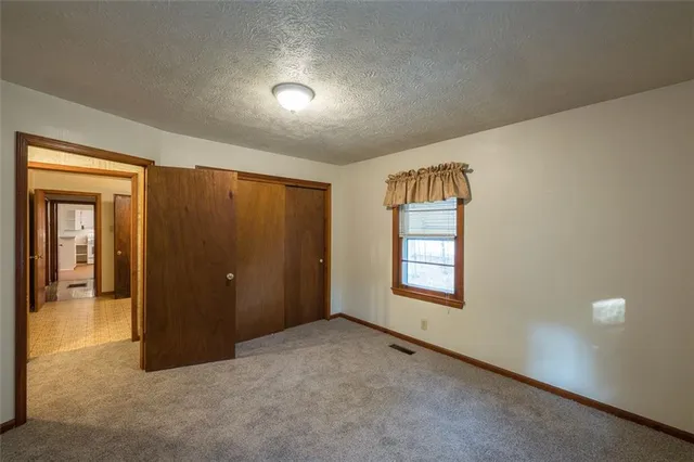an empty room with windows and closet