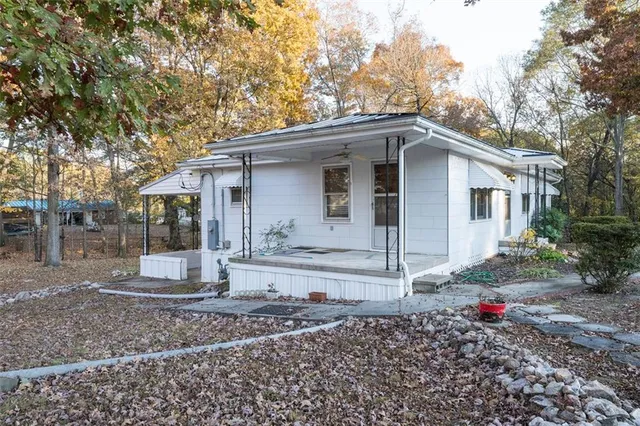 a view of a house with a yard and large tree