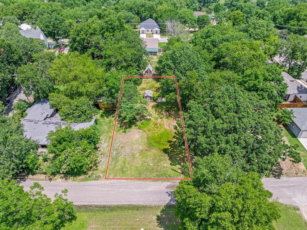 an aerial view of a house with a yard and large trees