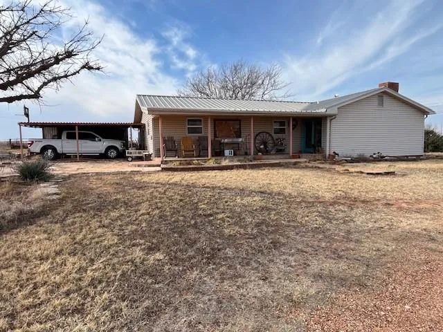 a view of a house with a yard and sitting area