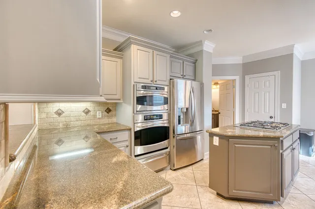 a kitchen with stainless steel appliances granite countertop a stove a sink and a refrigerator