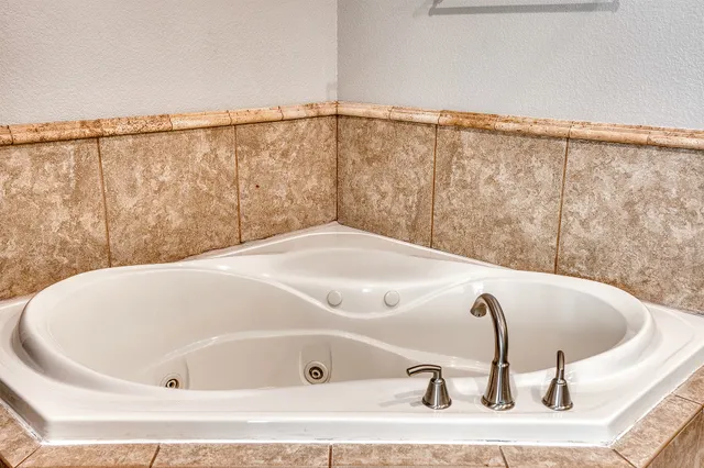 a bathroom with a tub and mirror