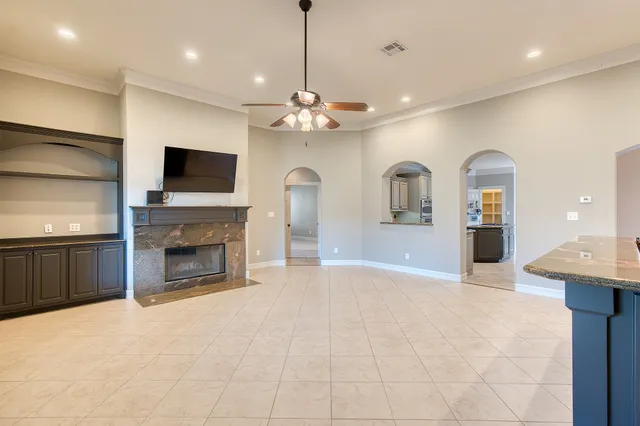 a view of a livingroom with a fireplace a sink and a chandelier