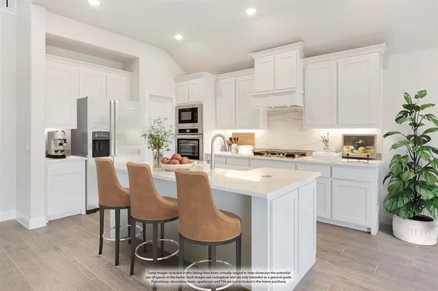 a kitchen with granite countertop white cabinets and stainless steel appliances