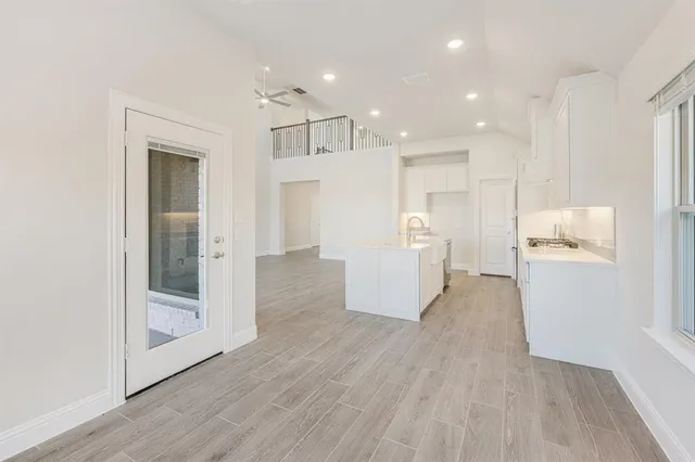 a view of a big room with wooden floor and windows