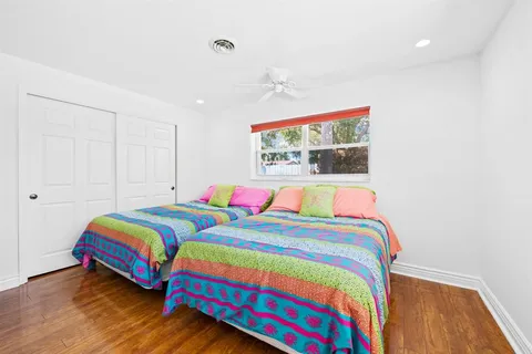 a bedroom with two beds and a painting on the wall