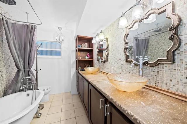 a bathroom with a granite countertop sink a mirror and shower