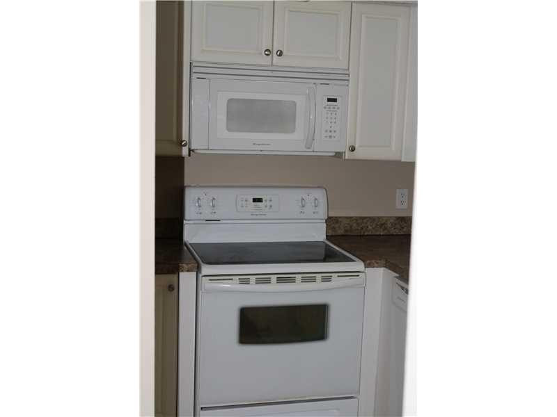 6364 La Costa Drive, Unit B Boca Raton, FL 33433 - Photo 6 of 19 a kitchen with a stove and white cabinets
