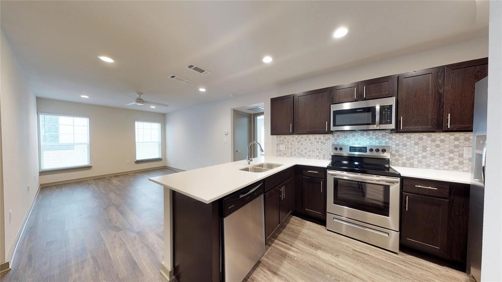 a kitchen with stainless steel appliances granite countertop a stove a sink and a microwave
