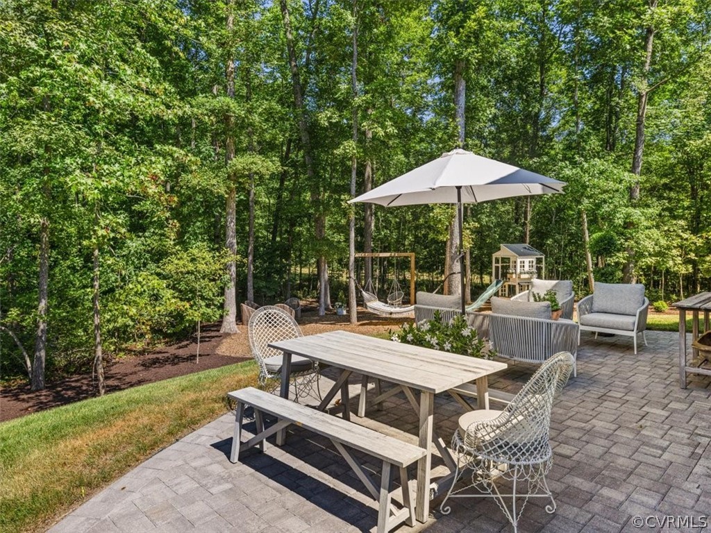 16701 Saville Chase Road Midlothian, VA 23112 - Photo 46 of 50 a view of a patio with a table and chairs under an umbrella