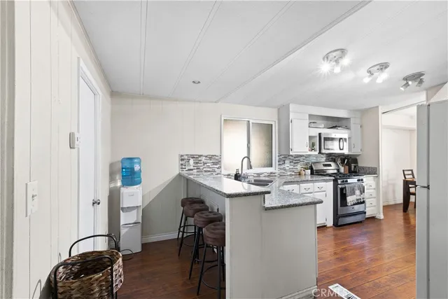 a kitchen with a sink cabinets and wooden floor