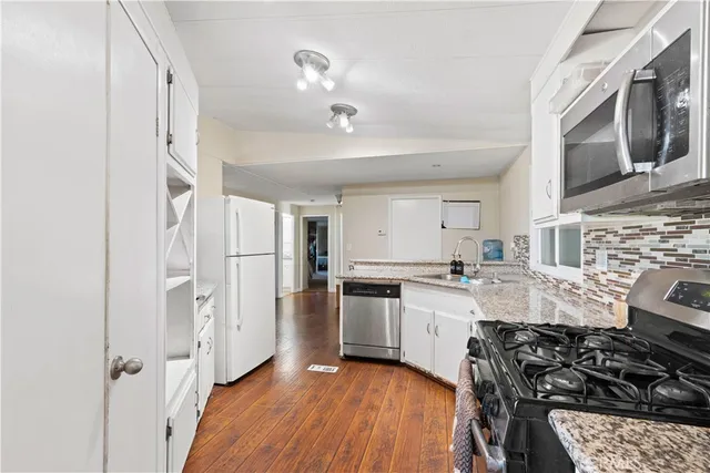 a kitchen with stainless steel appliances a stove a sink and a refrigerator