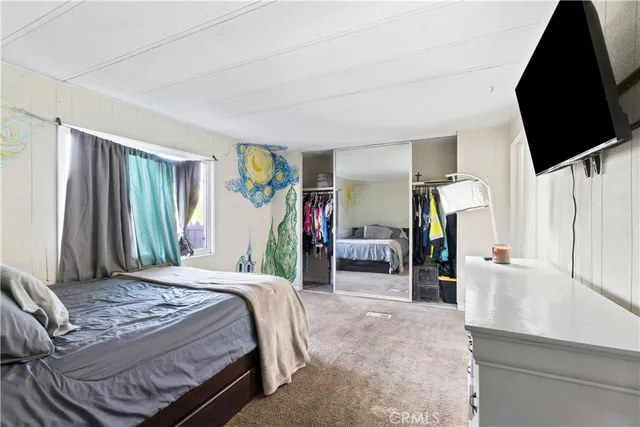 a bedroom with a bed and a flat tv screen