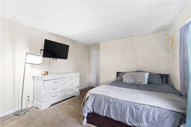 a bedroom with a bed and flat screen tv