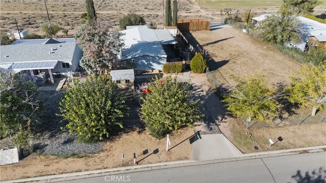 aerial view of a house with a yard and large trees