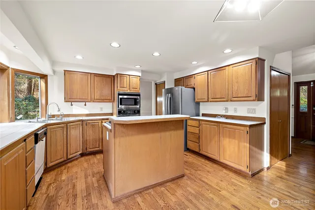 a kitchen with granite countertop cabinets stainless steel appliances and a window