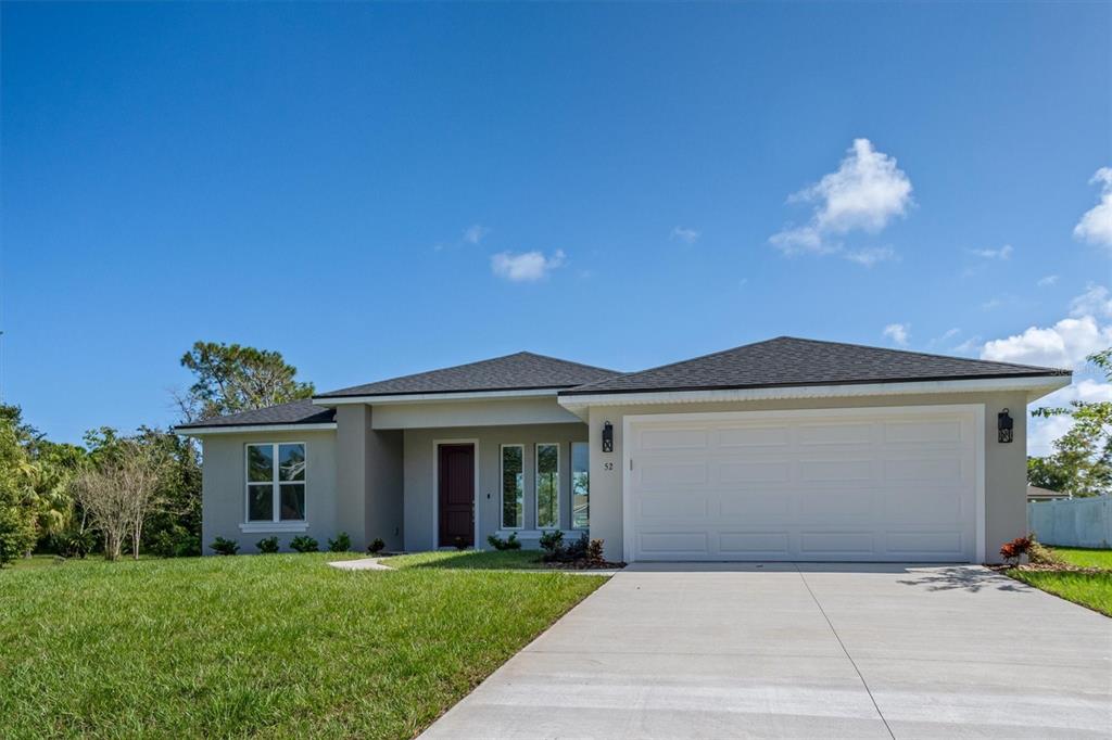 52 Pershing Lane Palm Coast, FL 32164 - Photo 1 of 37 a front view of a house with a yard and garage