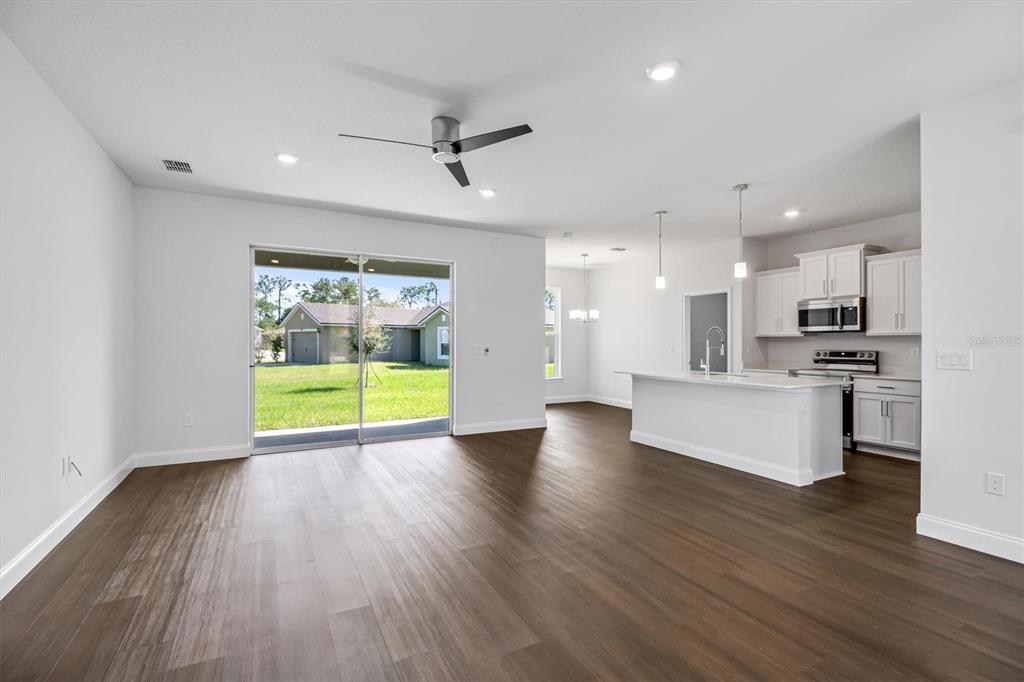 52 Pershing Lane Palm Coast, FL 32164 - Photo 11 of 37 a view of an empty room with kitchen and a floor to ceiling window