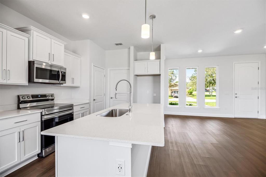 52 Pershing Lane Palm Coast, FL 32164 - Photo 13 of 37 a kitchen with a stove a sink and a microwave