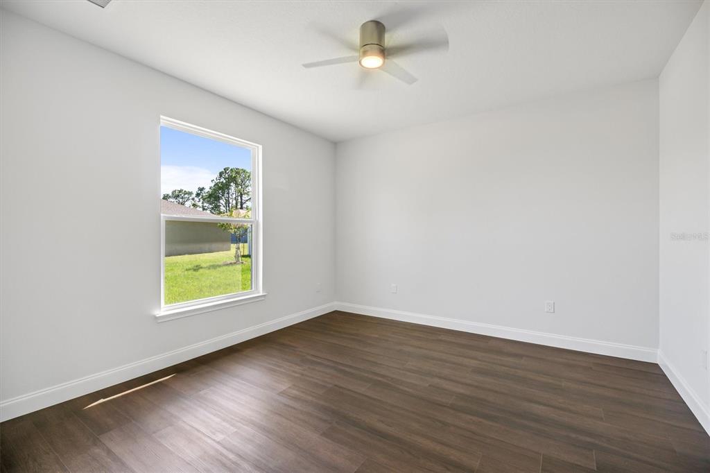 52 Pershing Lane Palm Coast, FL 32164 - Photo 14 of 37 an empty room with wooden floor and windows