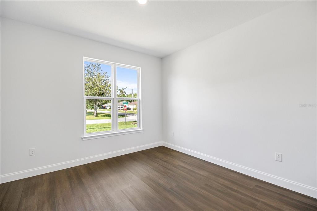 52 Pershing Lane Palm Coast, FL 32164 - Photo 20 of 37 an empty room with wooden floor and windows